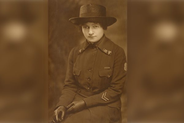 WWI Nurse in uniform seated with hat